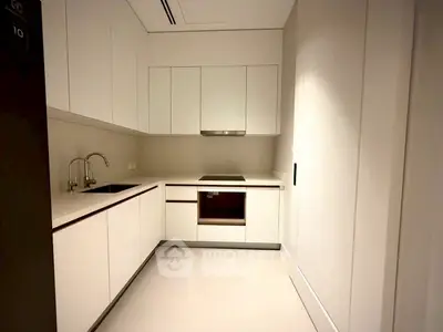 Modern kitchen with sleek white cabinetry and built-in appliances in a contemporary apartment.