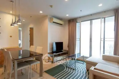 Modern living room with dining area, large windows, and stylish furniture in a bright apartment.