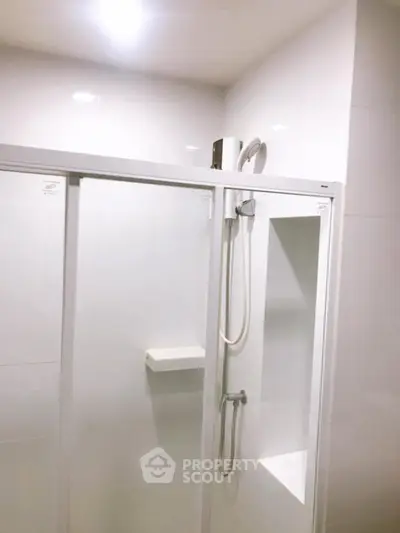 Modern bathroom with sleek shower enclosure and white tiles
