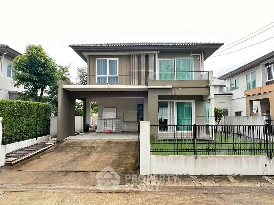 Modern two-story house with driveway and lush greenery in a serene neighborhood.