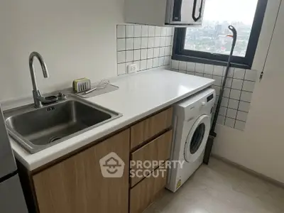 Compact kitchen with washing machine and city view window