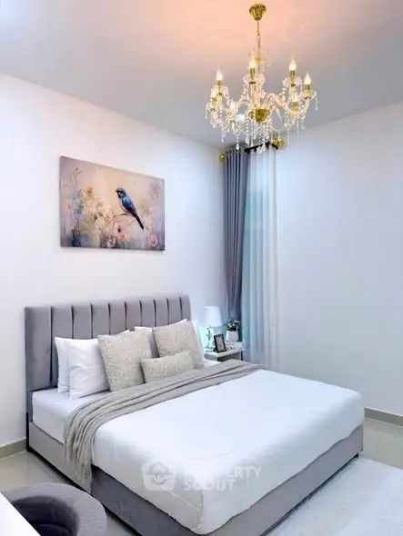 Elegant bedroom with plush bed, chandelier, and stylish decor