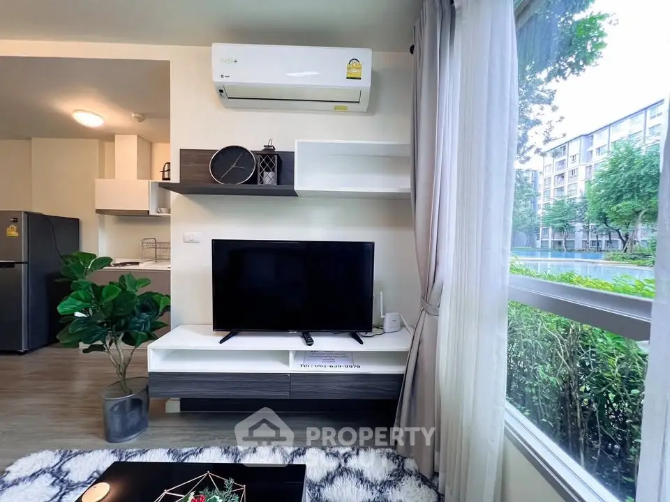 Modern living room with air conditioning, TV, and large window view in stylish apartment.