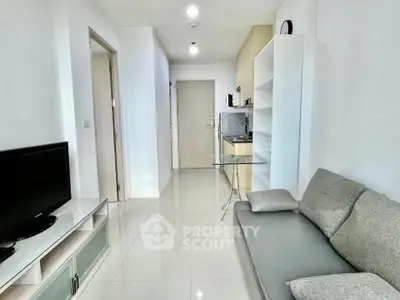 Modern living room with sleek furniture and minimalist design, featuring a cozy sofa and flat-screen TV.