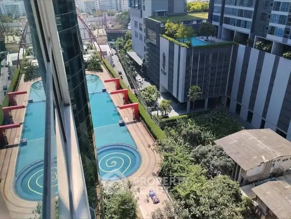 Stunning aerial view of modern residential complex with luxurious pool and lush greenery.