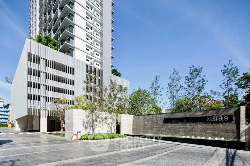 Modern high-rise building with sleek design and landscaped entrance at Nara 9.