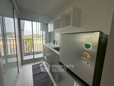 Modern kitchen with balcony view and sleek appliances in a stylish apartment.