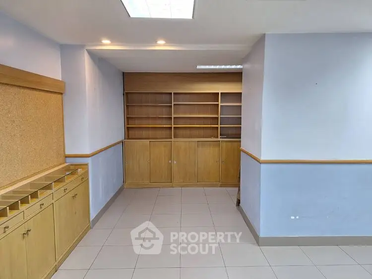 Spacious study room with built-in wooden shelves and cabinets