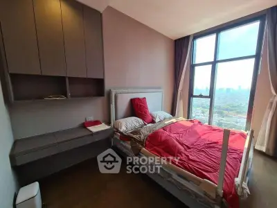 Modern bedroom with large window offering stunning city views, featuring stylish furniture and cozy bedding.