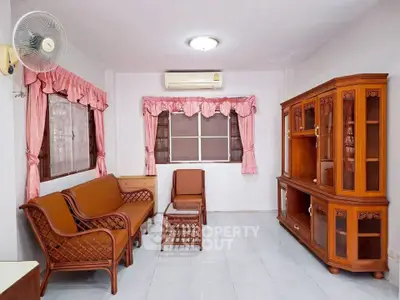 Charming living room with vintage wooden furniture and pink curtains, perfect for cozy family gatherings.