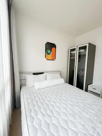 Bright bedroom with modern decor and large window, featuring a comfortable bed and stylish wardrobe.