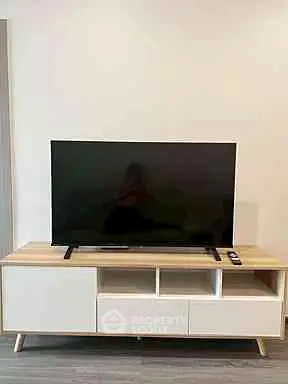 Modern living room with sleek TV stand and flat-screen television, perfect for entertainment.