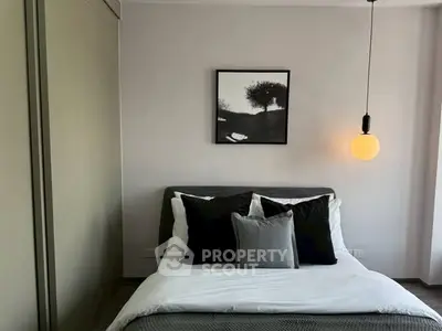 Modern bedroom with stylish decor and cozy lighting, featuring a comfortable bed and elegant wall art.