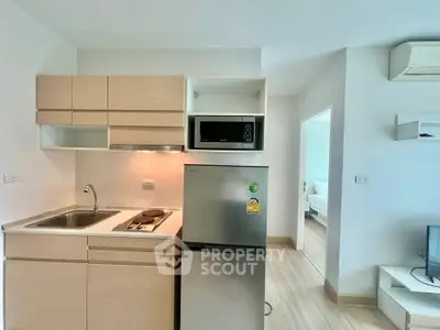 Modern compact kitchen with fridge and microwave in stylish apartment