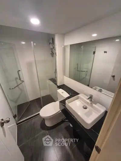 Modern bathroom with sleek design, glass shower, and stylish fixtures in a contemporary apartment.