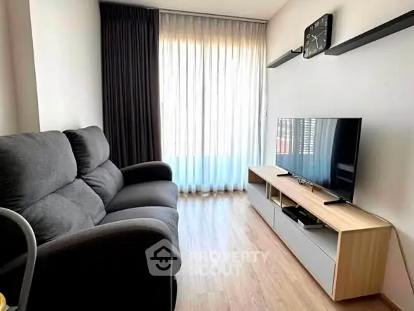 Modern living room with sleek furniture and large window for natural light.