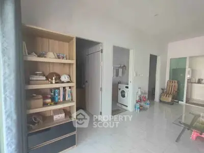 Spacious modern living area with bookshelf and laundry room access