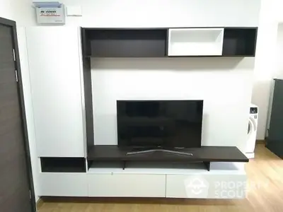 Modern living room with sleek TV unit and washing machine corner