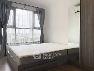 Spacious bedroom with large window and modern wardrobe in urban apartment