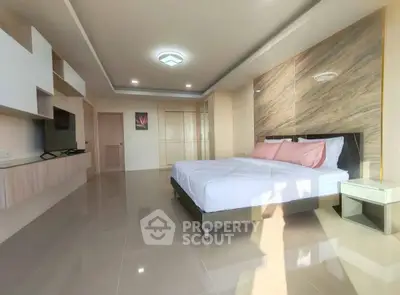 Spacious modern bedroom with elegant decor and ample natural light