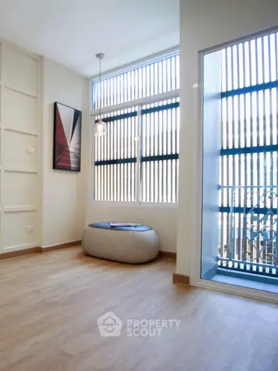 Bright and modern room with large windows and stylish decor, perfect for relaxation.