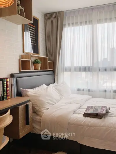 Cozy bedroom with modern decor and large window for natural light