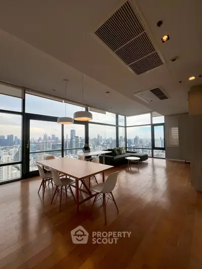Spacious modern living room with panoramic city views and elegant dining area.