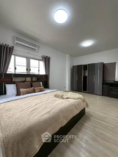 Spacious modern bedroom with stylish decor and ample natural light