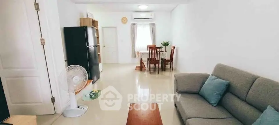 Spacious living room with modern furniture and dining area in a bright apartment.