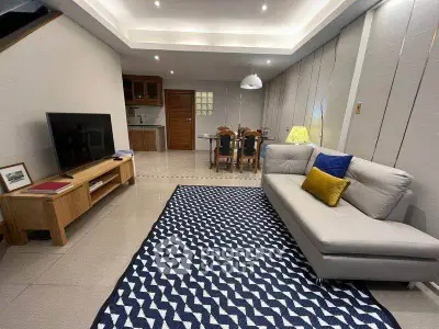Spacious living room with modern decor and open kitchen layout