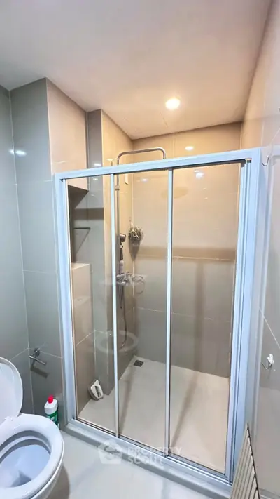 Modern bathroom with glass shower enclosure and sleek design.