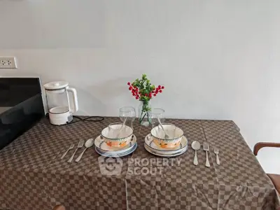 Charming dining setup with elegant tableware and floral centerpiece in cozy kitchen corner.