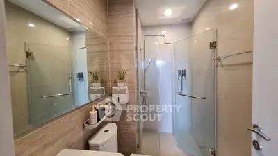 Modern bathroom with glass shower and elegant fixtures in a stylish apartment.