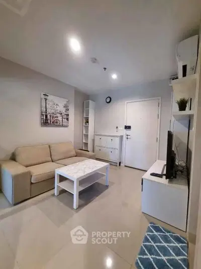 Modern living room with beige sofa, white furniture, and stylish decor.