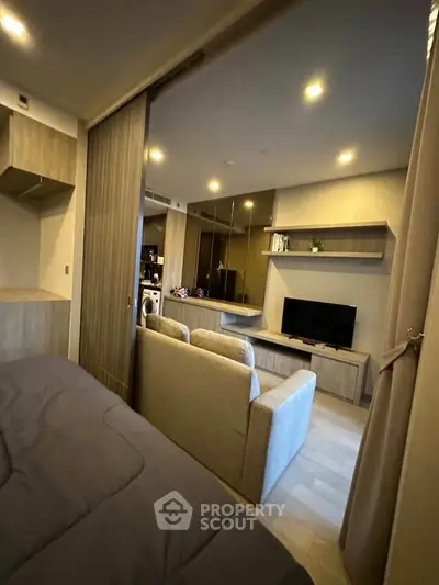 Modern studio apartment with cozy living area and built-in storage solutions.