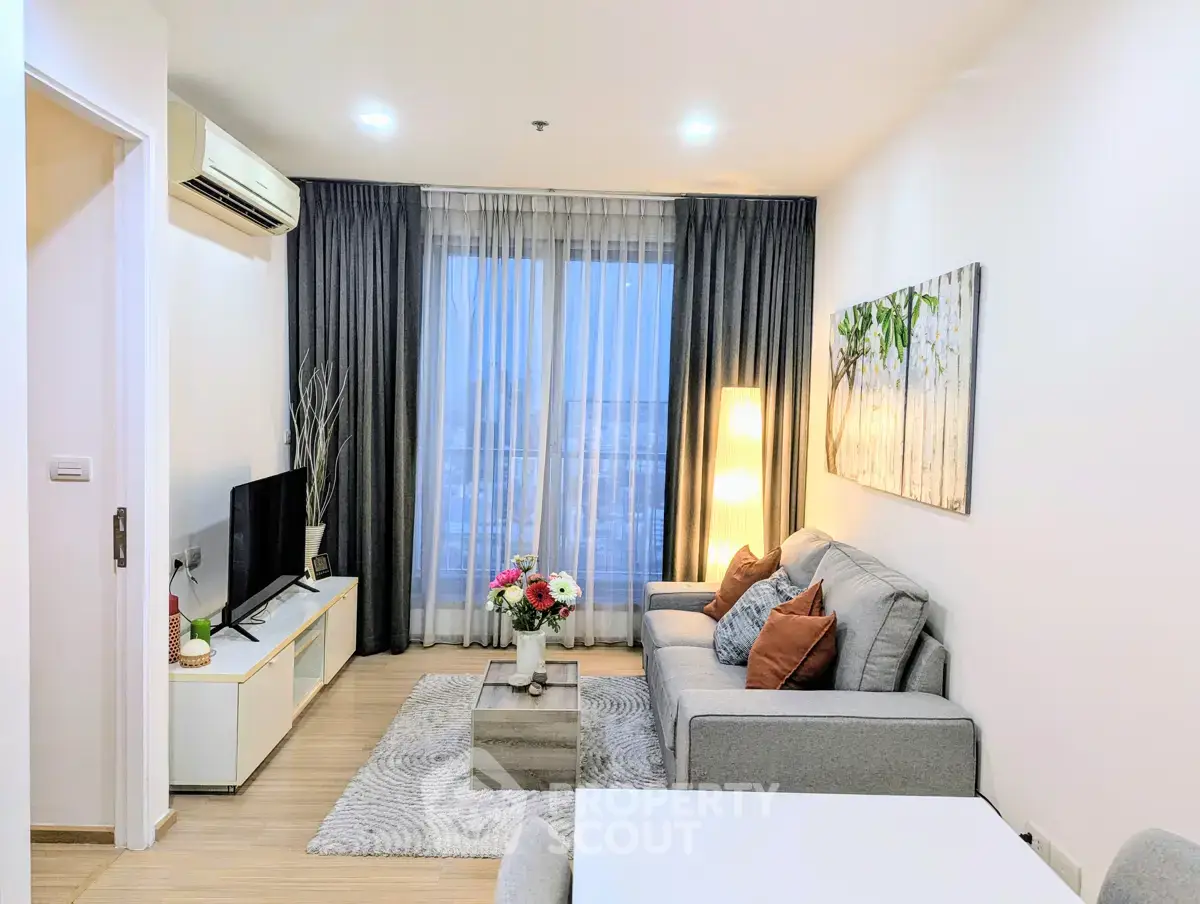 Modern living room with stylish decor, cozy seating, and natural light from large windows.