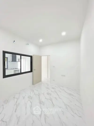 Bright and modern room with marble flooring and recessed lighting, showcasing a sleek interior design.