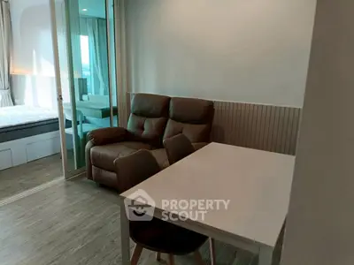 Cozy living room with modern furniture and sliding glass doors to bedroom