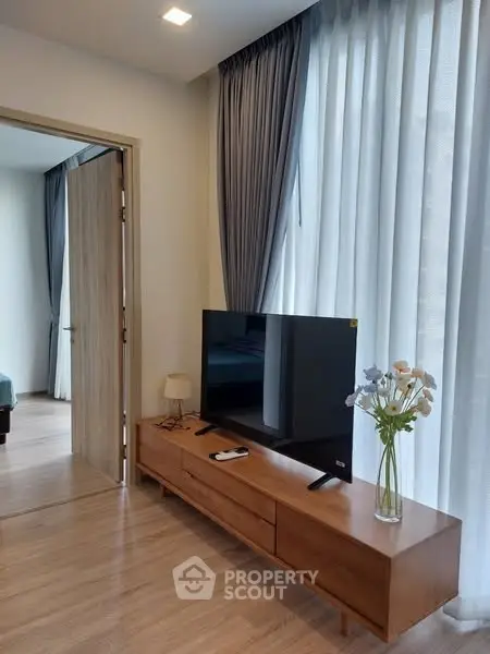 Modern living room with sleek TV stand and elegant curtains, showcasing a cozy and inviting atmosphere.