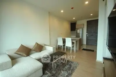 Modern living room with cozy sofa and dining area in open layout apartment.