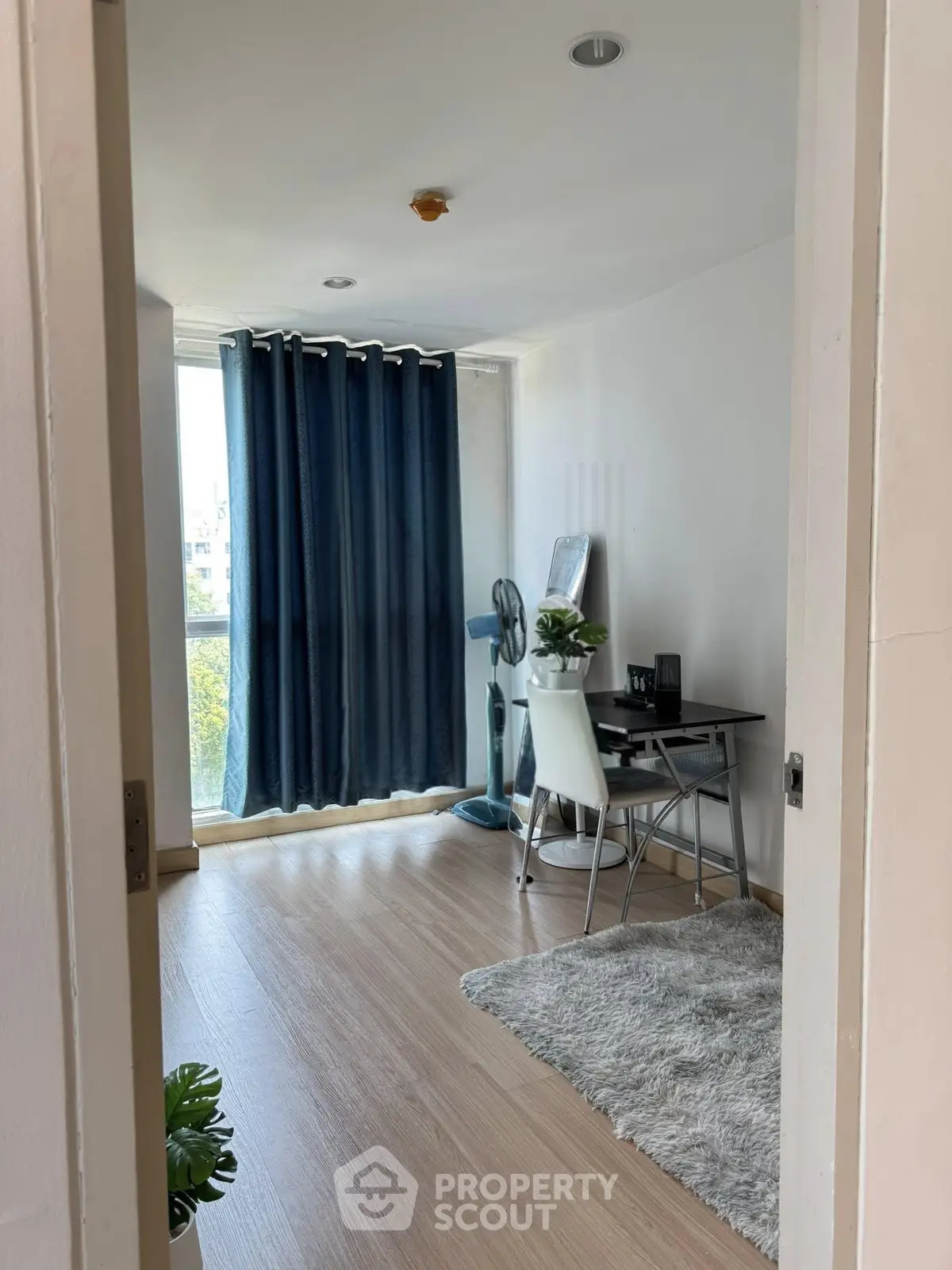 Modern study room with natural light, wooden flooring, and stylish decor in a contemporary apartment.