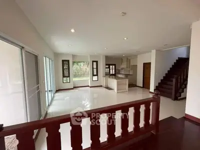 Spacious open-plan living area with modern kitchen and elegant staircase