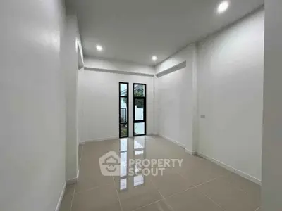 Spacious empty room with glossy tiled floor and large windows, perfect for customization.