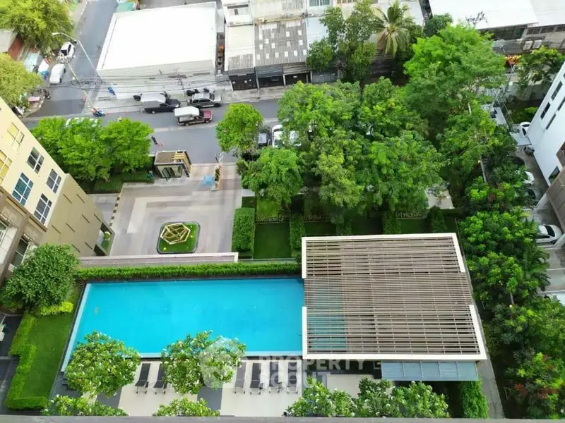 Stunning aerial view of modern residential complex with pool and lush greenery.