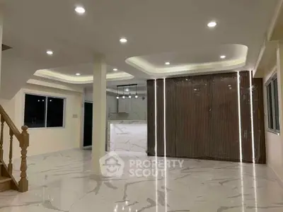 Spacious modern living room with elegant marble flooring and stylish lighting.