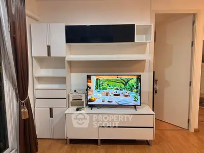 Modern living room with sleek white entertainment unit and TV, showcasing stylish interior design.