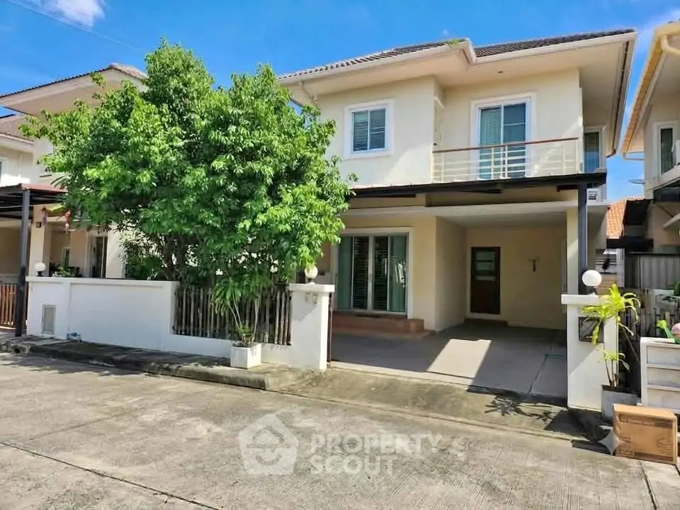 Charming two-story house with spacious driveway and lush greenery in a serene neighborhood.