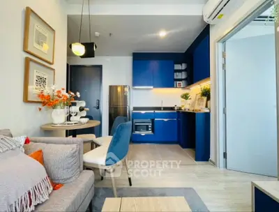 Modern open-layout living room and kitchen with blue cabinets and stylish decor.