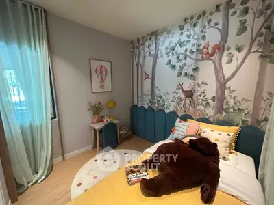 Charming children's bedroom with forest-themed wallpaper and cozy decor