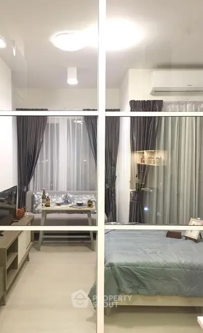 Modern studio apartment with cozy bedroom and stylish living area, featuring elegant decor and ample natural light.